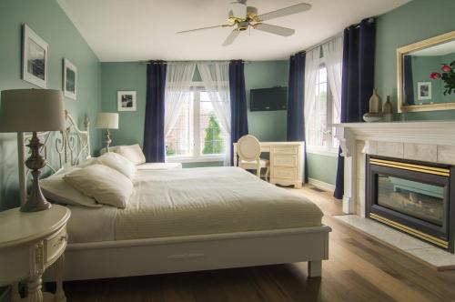 um quarto com uma cama branca e uma lareira em In Elegance em Niagara-on-the-Lake