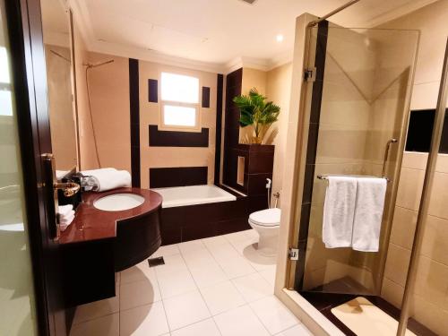 a bathroom with a shower and a toilet and a sink at Luxury 3 Bedroom Villa MSQ Muscat Parkside Retreat in Muscat