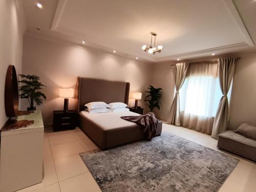 a bedroom with a bed and a couch and a window at Luxury 3 Bedroom Villa MSQ Muscat Parkside Retreat in Muscat