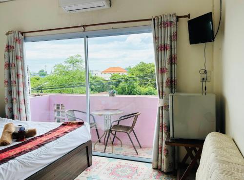 a bedroom with a bed and a balcony with a table at Home One Love Ayutthaya GH in Phra Nakhon Si Ayutthaya