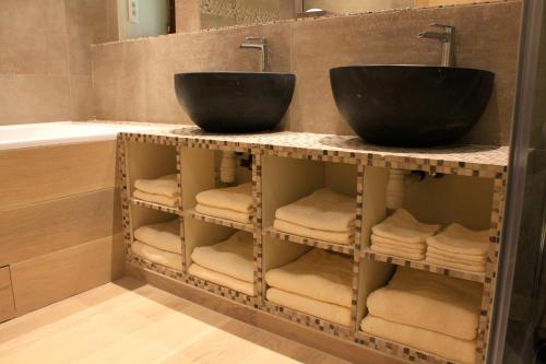 y baño con 2 lavabos, toallas y bañera. en La Grande Maison de Pont Lung, en Ygrande