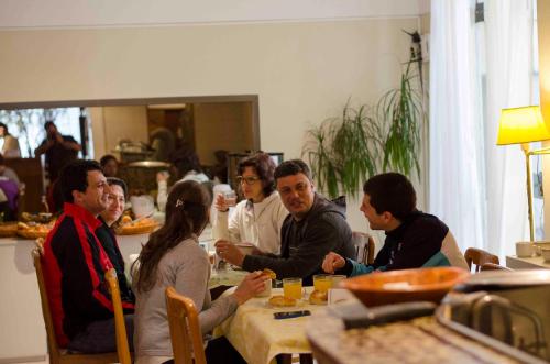 Un groupe de personnes assises autour d'une table dans l'établissement Hotel Bertaina, à Santa Fe