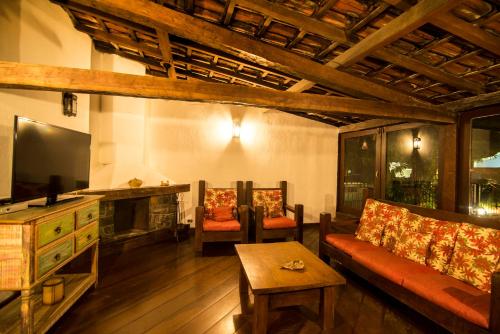 a living room with a couch and a fireplace at Pousada Perequê in Ilhabela