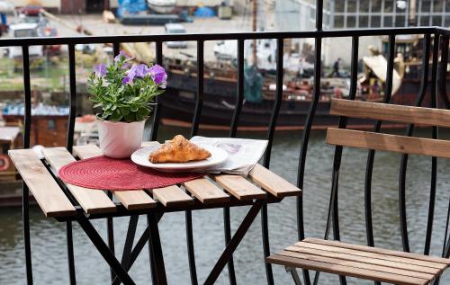 a wooden table with a plate of food and a plant at Portobello in Ustka