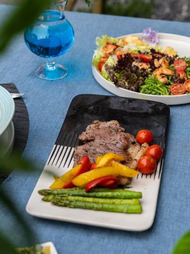 two plates of food on a table with meat and vegetables at Guilin Tranquil Peaks Retreat by Reed Flute Cave in Guilin