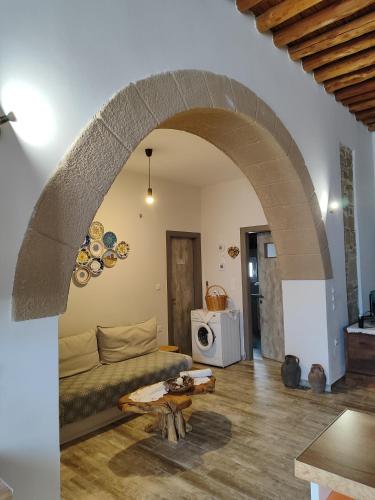a living room with a couch and an archway at Flora's Traditional House in Malona Village