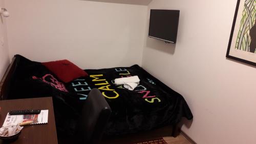 a bed in a room with a black comforter at Hostel IN Club in Zagreb