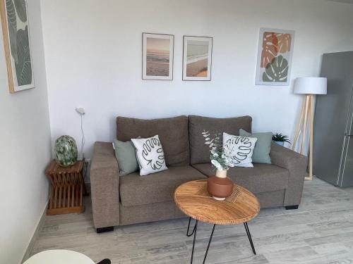 a living room with a couch and a table at Apartamerica 471, Gartenwohnung, Pool, 150 M zum Strand, Las Americas in Costa de Adeje