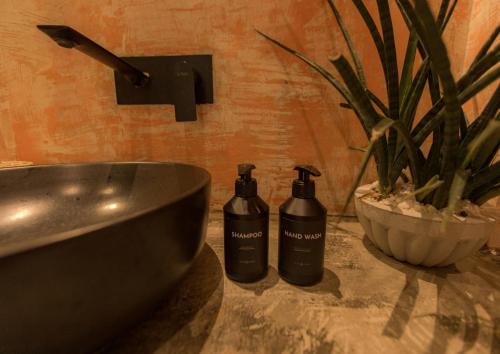 two shampoo bottles sitting on a counter next to a sink at Roaming Retreat Ahangama in Ahangama