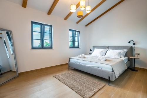 a bedroom with a bed with a rug and windows at Casa Eva in Opric