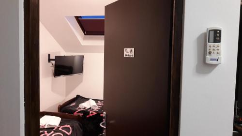 a door to a room with a cell phone on the wall at Hostel IN Club in Zagreb