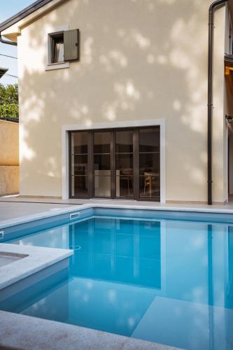 a swimming pool in front of a house at Casa Eva in Opric