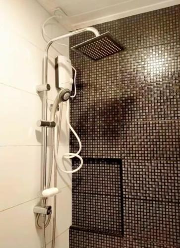 a shower in a bathroom with a tiled wall at Close by landmarks and airport in Manila