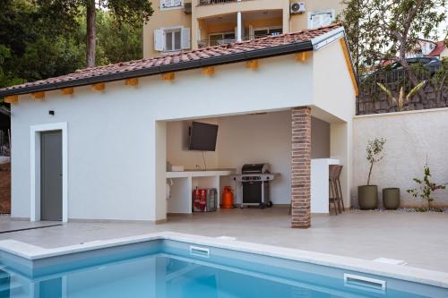 a villa with a swimming pool next to a house at Casa Eva in Opric