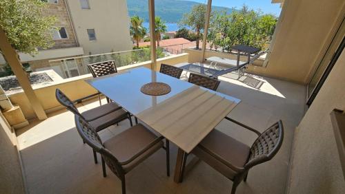 a table and chairs on a balcony with a view at Bella Vista Pleasure in Baošići