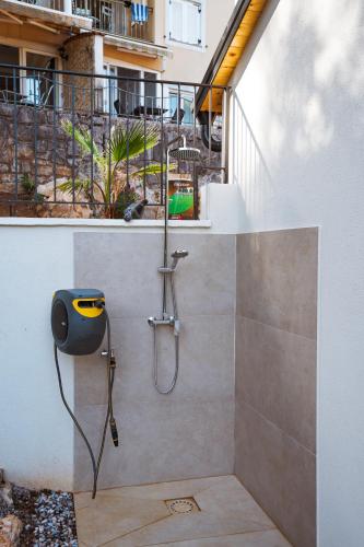 a shower with a hose attached to a wall at Casa Eva in Opric
