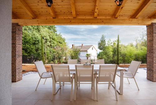 a dining room with a table and chairs on a patio at Casa Eva in Opric