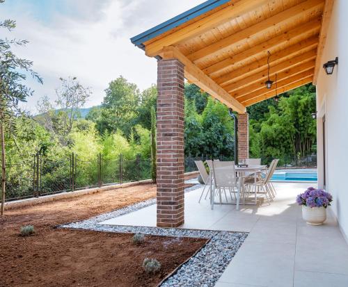 a patio with a table and a wooden roof at Casa Eva in Opric