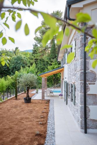 a stone house with a courtyard and a pool at Casa Eva in Opric