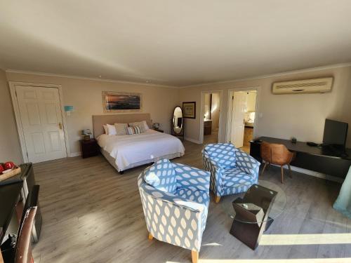 a hotel room with a bed and two chairs at Hout Bay Breeze Guest House in Hout Bay