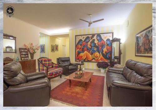 a living room with couches and a painting on the wall at Colonel’s Retreat in New Delhi