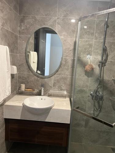 Un baño con lavabo y ducha con espejo. en Tễu homestay, en Hai Phong