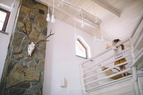 a person standing on the stairs of a house with a skull on the wall at Carlina House in Szczawnica