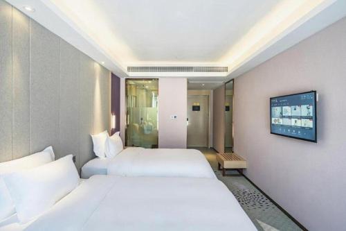 a hotel room with two beds and a tv at Lavande Hotel Jiande Xin'an River in Thousand Island Lake