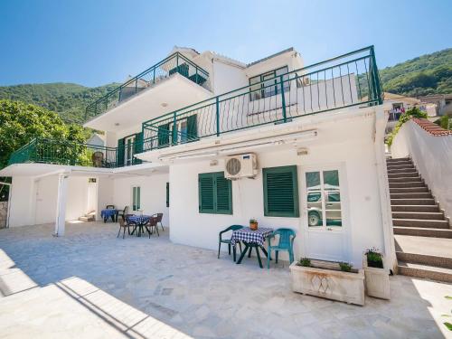 a white house with a balcony and a patio at Apartments Iva in Kotor