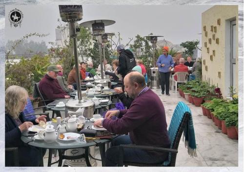 a group of people sitting at tables at an outdoor restaurant at Colonel’s Retreat in New Delhi