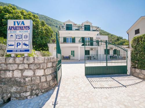 a sign in front of a gate in front of a house at Apartments Iva in Kotor
