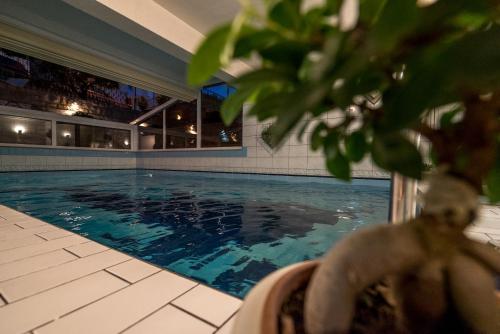 a man sitting in a chair next to a swimming pool at Villa Solis in Split