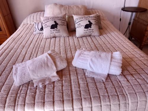 ein Bett mit weißen Handtüchern und Kissen darauf in der Unterkunft Emilia in Barraquero