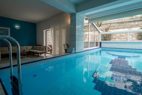 a large swimming pool with blue walls and a large window at Villa Solis in Split