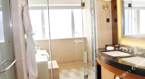 a bathroom with a glass shower and a sink at Radegast Hotel CBD in Beijing