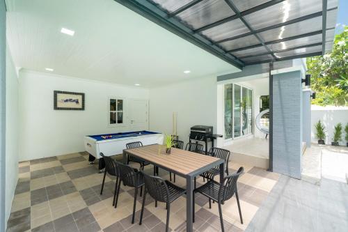 a dining room with a ping pong table and chairs at 7BR Grand Pool Villa in heart Patong in Patong Beach