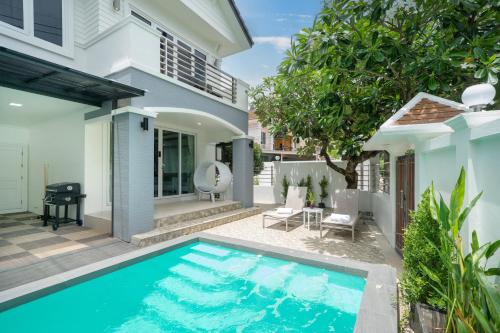 a swimming pool in front of a house at 7BR Grand Pool Villa in heart Patong in Patong Beach
