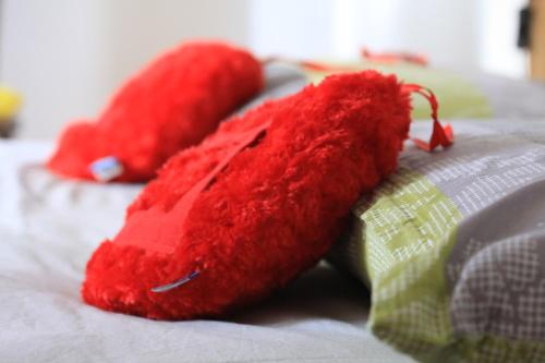 two red stuffed hearts sitting on a bed at Maison Soleil - Mansarda in Aosta