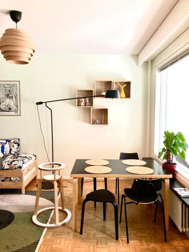 a living room with a table and chairs at Moomin Lover Home in Central Helsinki - Pool & Sauna in Helsinki