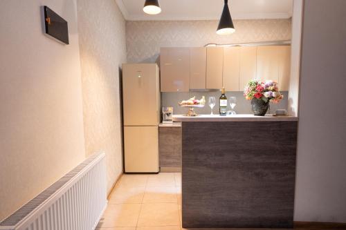 a kitchen with a refrigerator and a counter with flowers at Stylish Central Apartment in TbilisiGreat Location in Tbilisi City