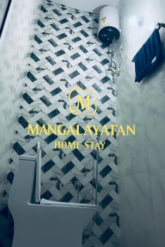a bathroom with a sign on ailed wall at Mangalayatan Home Stay Ayodhya in Faizābād