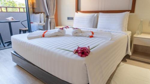 a bedroom with a large white bed with flowers on it at Aquaraa in Maduvvari