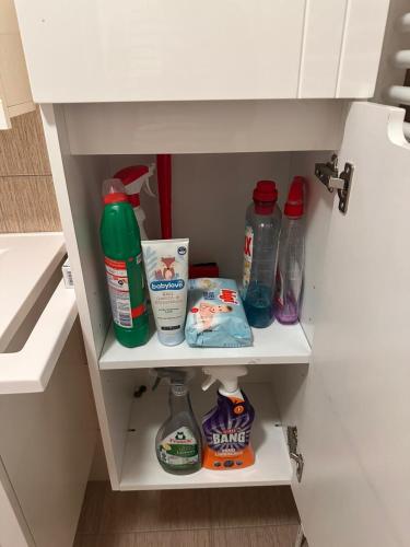 a cupboard with bottles of detergent and other cleaning products at Stan apartman Ilidza in Sarajevo