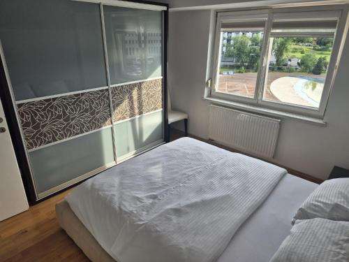a bedroom with a white bed and a window at Stan apartman Ilidza in Sarajevo