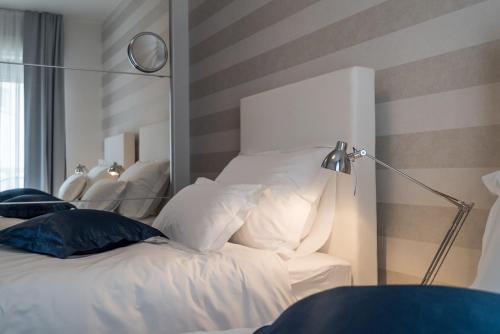 a bedroom with a bed with white pillows and a lamp at Villa Solis in Split