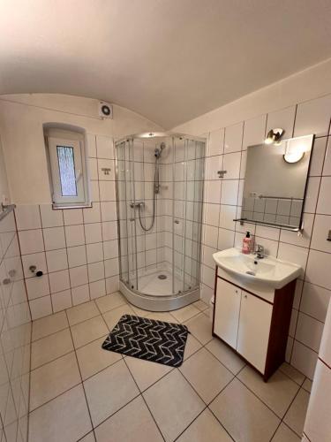 a bathroom with a shower and a sink at Noclegi Fikusówka in Opole