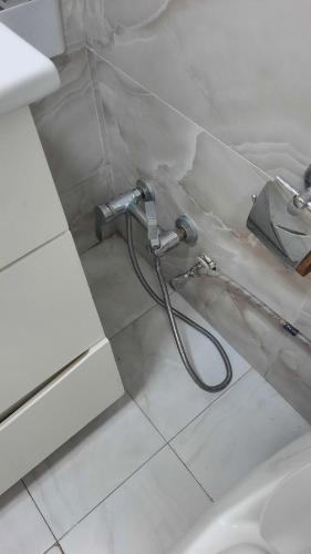 a bathroom with a shower hose on the floor at Halal House Vip in Qusar