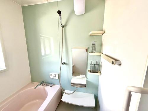 a bathroom with a sink and a bath tub with a mirror at Good Stay Apartment in Nichinan