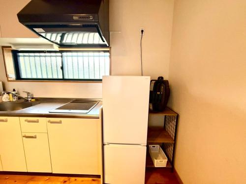 a white refrigerator in a kitchen with a window at Good Stay Apartment in Nichinan