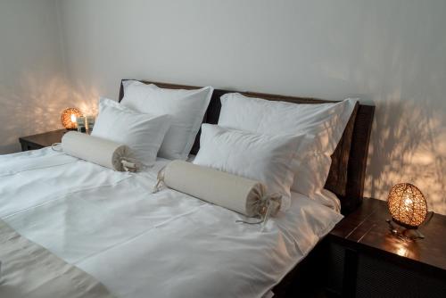 a white bed with white pillows and two candles on it at Villa Solis in Split